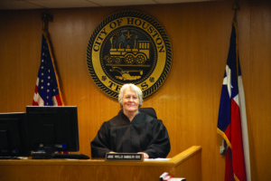 Phyllis Frye sits behind the bench in a judge's robe.